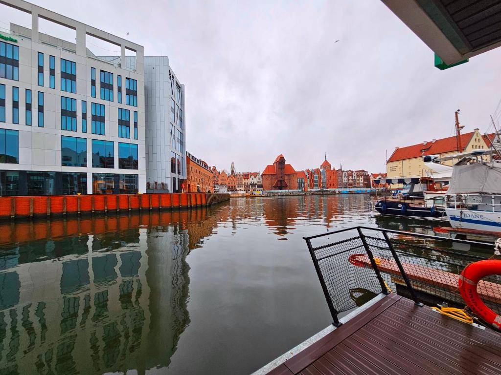 a view of a body of water with buildings at Domki na wodzie - Apartament Korweta Gdańsk - Stare Miasto flota Possession pl in Gdańsk