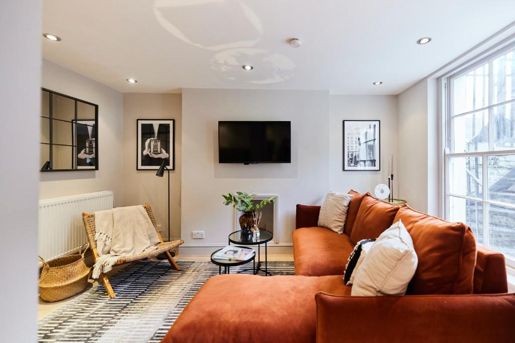 a living room with a couch and a tv at The Myddelton Square - Cosy 1BDR Flat in London