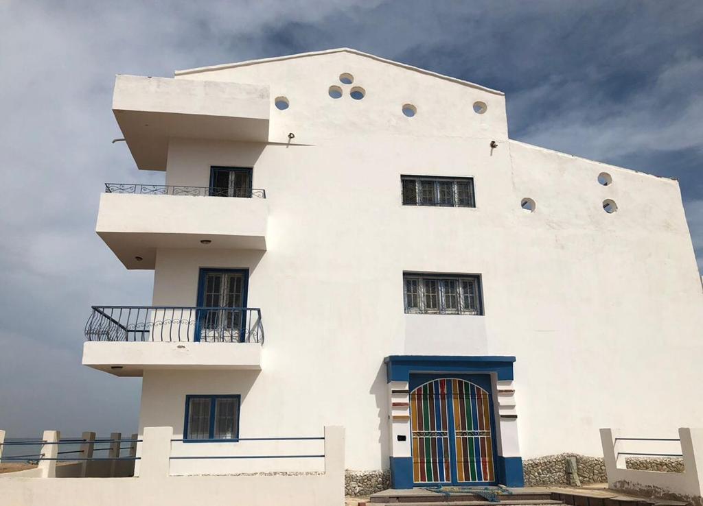 Biały budynek z dwoma balkonami na górze w obiekcie Das! Haus am Meer w mieście Safadża