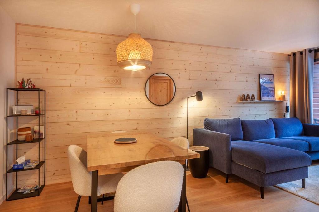 un salon avec un canapé bleu et une table dans l'établissement CHALENDE 12 : Au coeur du village et à 200m des pistes, à Morzine