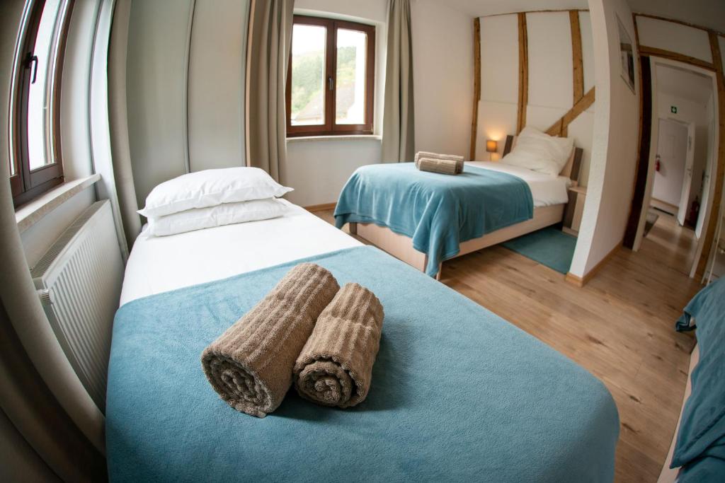 a hotel room with two beds with towels on the bed at The Ring Inn in Adenau