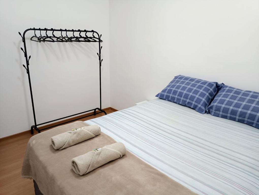 a bedroom with a bed with two pillows on it at Apartamento aconchegante Jd América in Maringá
