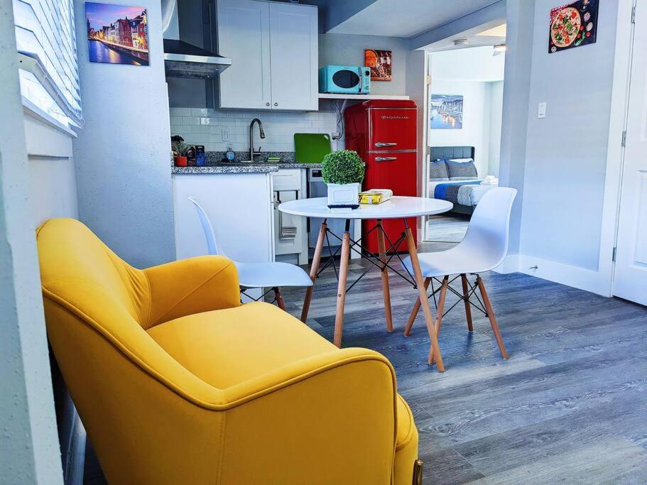 uma cozinha com um sofá amarelo e uma mesa e cadeiras em Elegant 1 Bed Montrose - Venice @ Italian Plaza em Houston