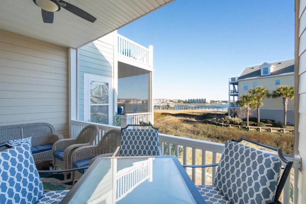 a porch with chairs and a table with a view of the ocean at 21 Turtle Bay Carolina Tides in Folly Beach