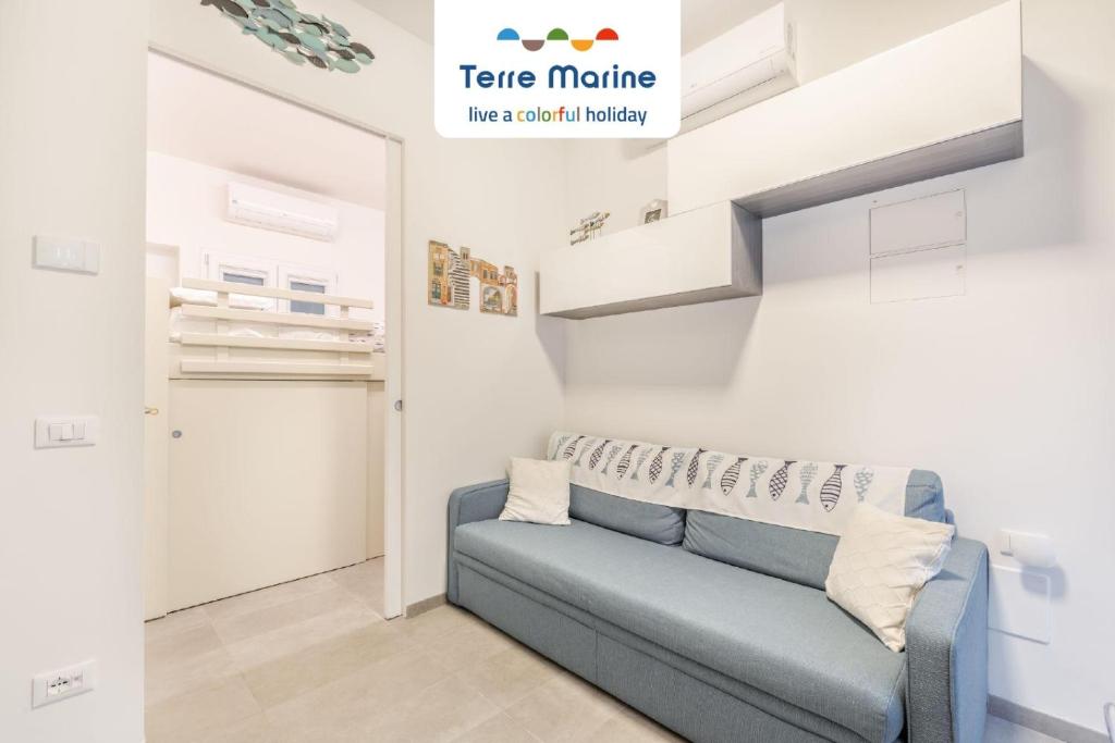 a living room with a blue couch in a room at La Perla del Mare, Terre Marine in Monterosso al Mare