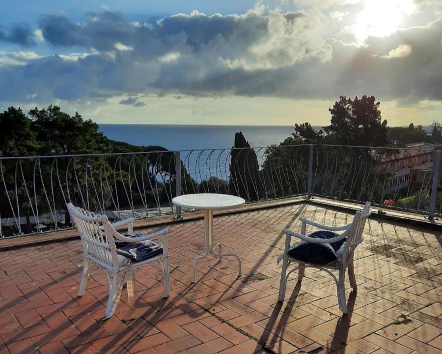 - 2 chaises et une table sur une terrasse donnant sur l'océan dans l'établissement Villa delle Palme - Goelba, à Capo D'Arco