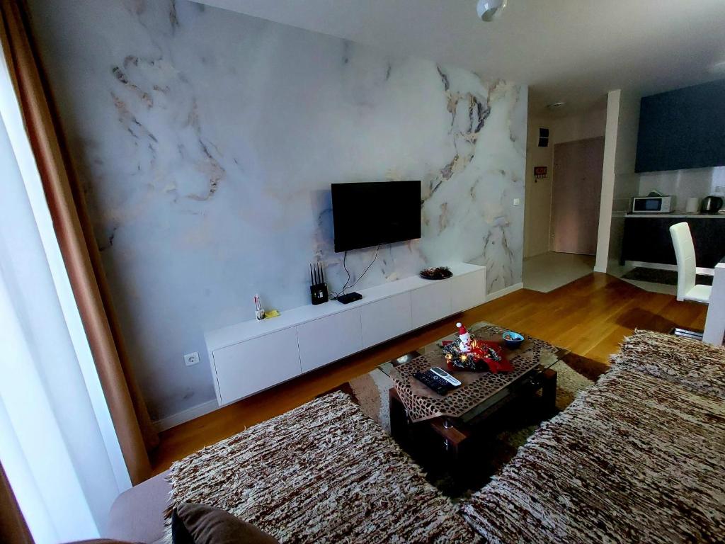 un soggiorno con TV su una parete bianca di New York - Central Point a Podgorica