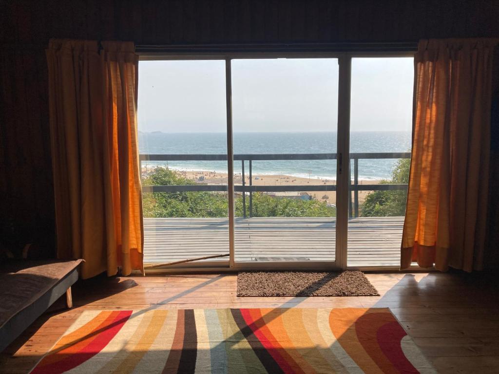 Habitación con ventana grande con vistas al océano. en Casa en algarrobo con hermosa vista al mar, en Algarrobo