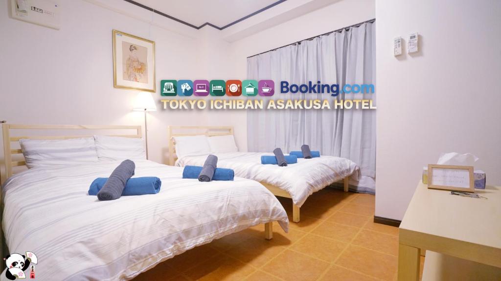 2 Betten mit blauen Kissen in einem Zimmer in der Unterkunft TOKYO ICHIBAN ASAKUSA in Tokio