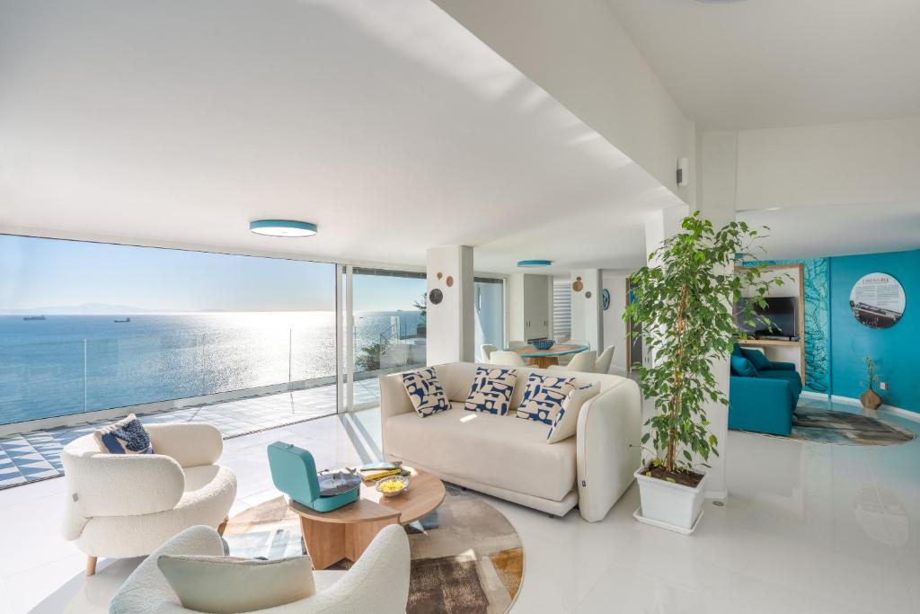 una sala de estar con muebles blancos y vistas al océano. en Laguna Blu - Resort Villa overlooking the sea on the Amalfi Coast en Vietri