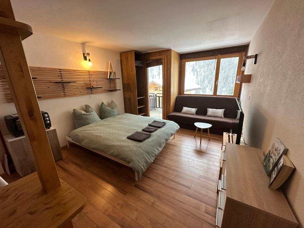 sala de estar con cama y sofá en Studio Bellevue 1, ski lift 350m, en Zinal