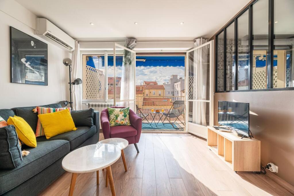 un salon avec un canapé et une grande fenêtre dans l'établissement 3 VIDAL - Splendide appartement 4 couchage hyper centre de Cannes, à Cannes