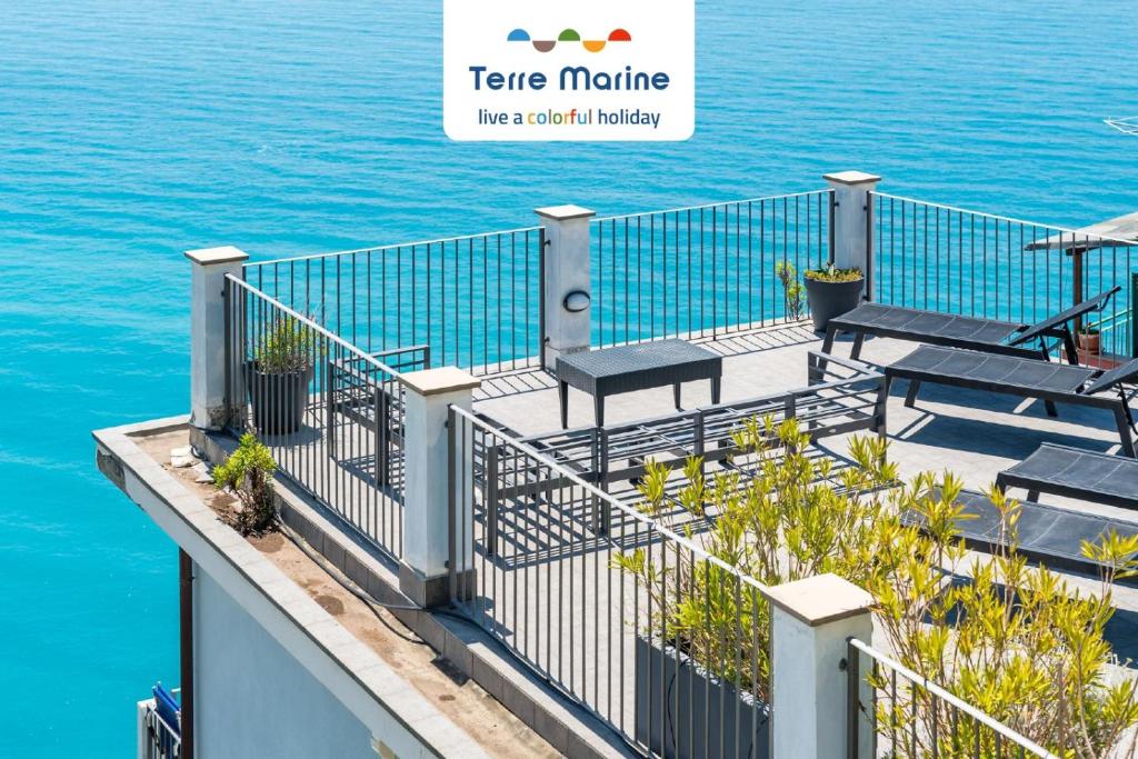 un balcone con panche e acqua di Casa Panorama, Terre Marine a Corniglia