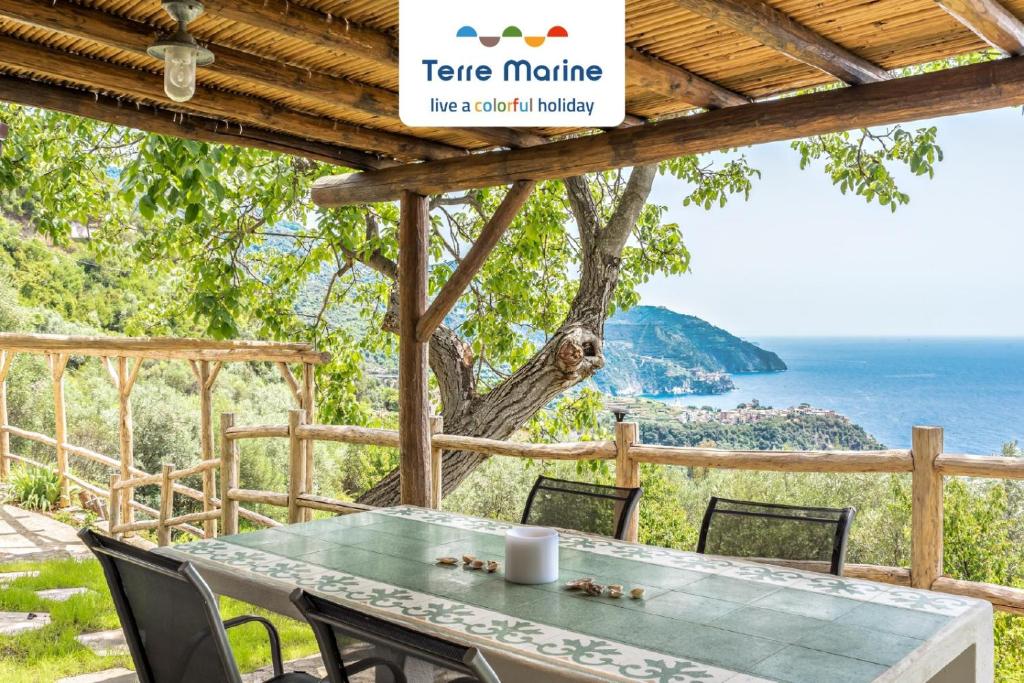 een tafel en stoelen met uitzicht op de oceaan bij Sound of Silence, Terre Marine in Corniglia