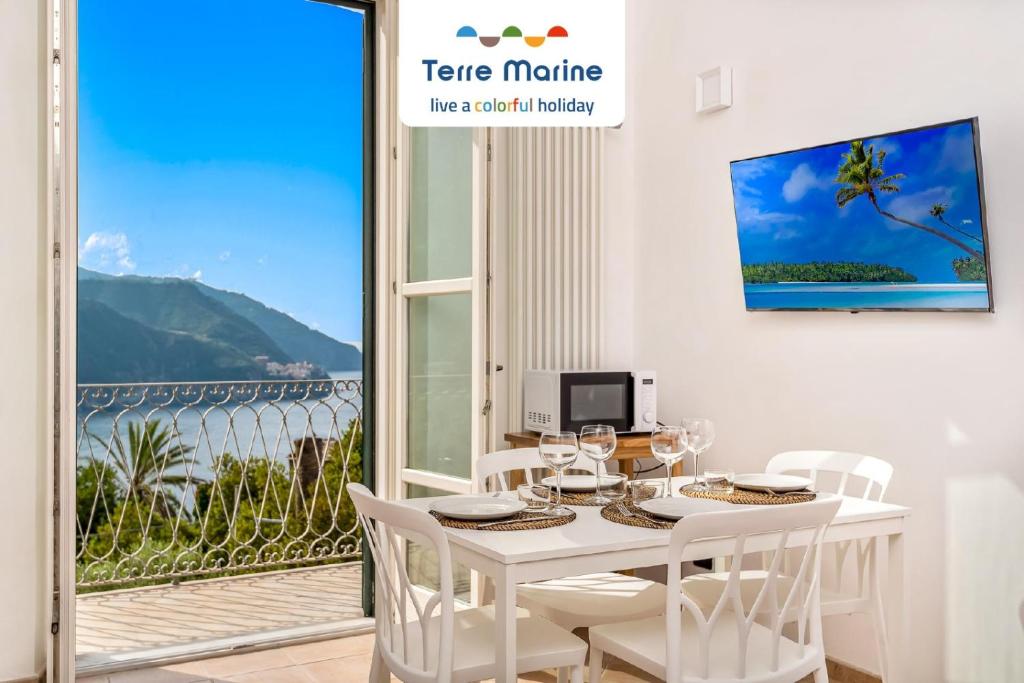 a white dining room with a table and chairs and a window at Pensieri Marini, TerreMarine in Corniglia