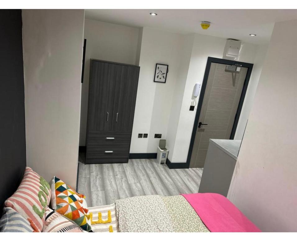 1 dormitorio con cama, armario y puerta en Impeccable 1-Bed Studio in London en Londres