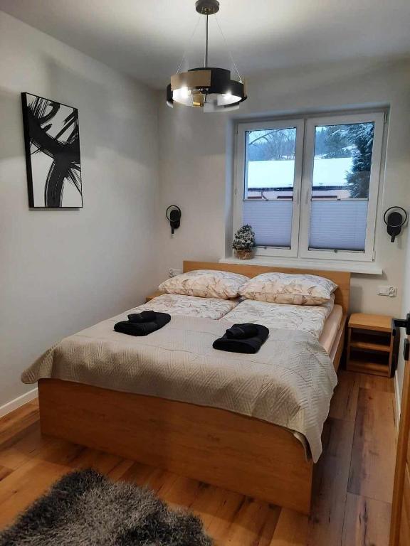 una camera da letto con un letto con due asciugamani neri di Apartamenty Zorza a Krynica-Zdrój