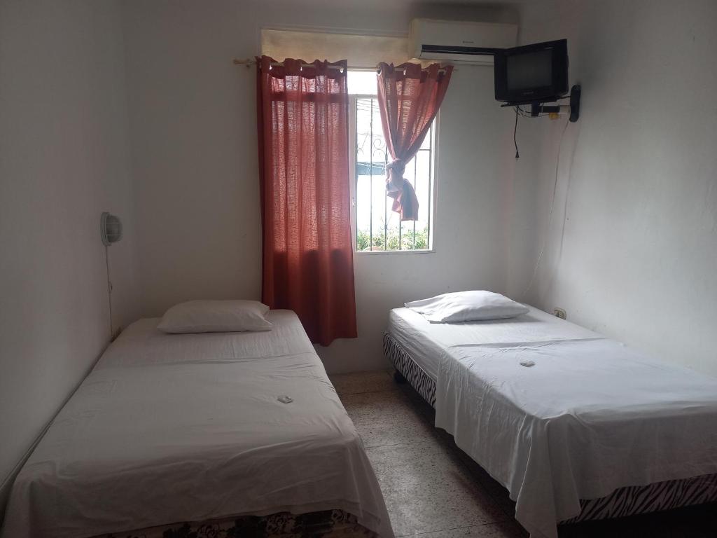 Duas camas num quarto com uma janela em Hostal Continental em Manta