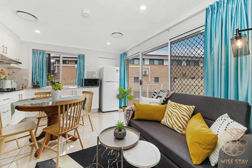 a living room with a couch and a table and a kitchen at Hurstville 2Br Granny flat near Shopping & Train in Sydney