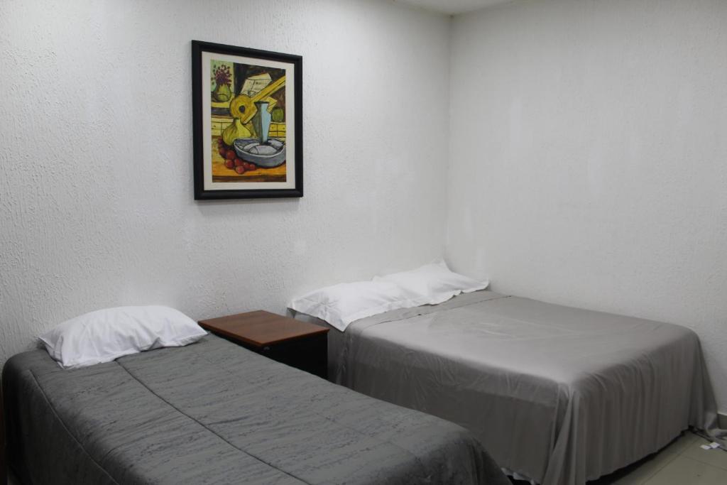 two beds in a room with a picture on the wall at AP 80- Apart OH in Ciudad del Este