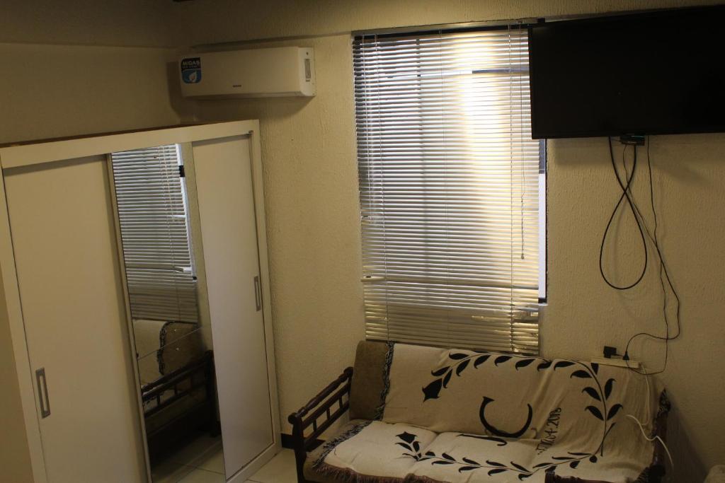 Pokój z oknem z kanapą i lustrem w obiekcie AP 10- Apart OH w mieście Ciudad del Este