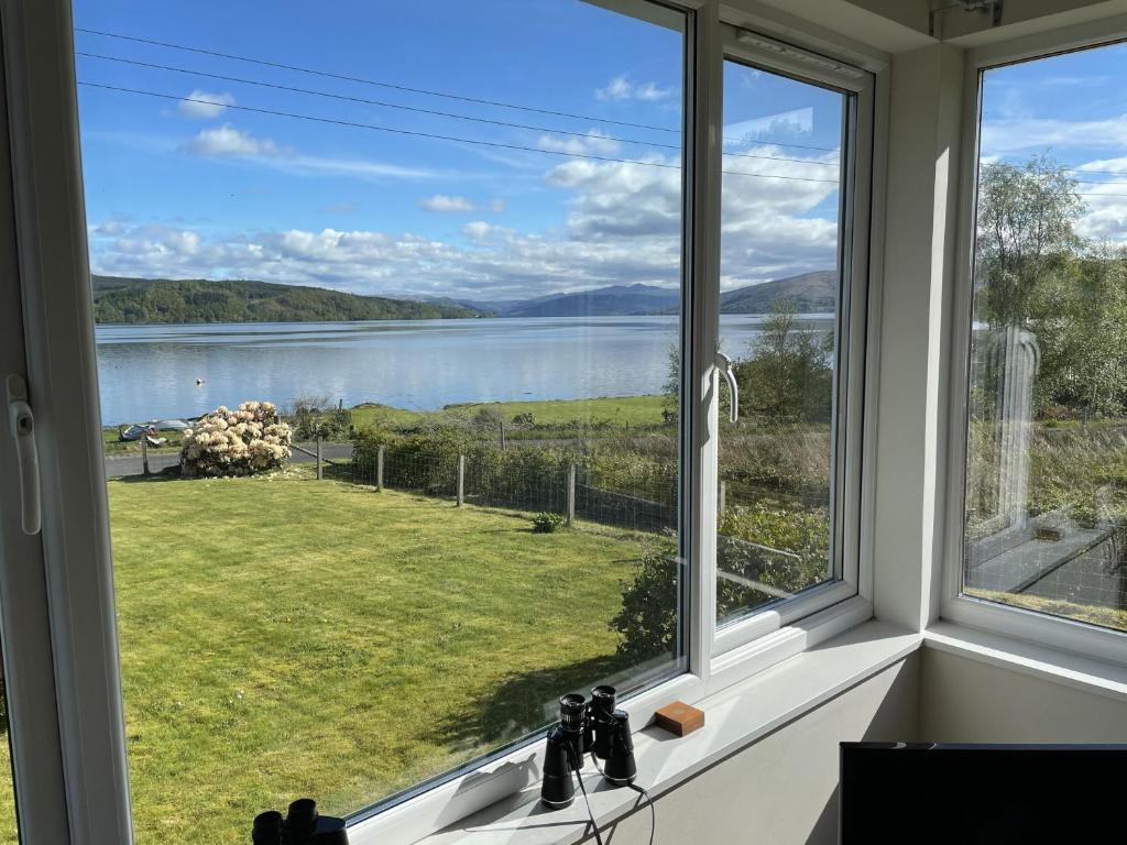 a window with a view of a lake at The Cottage, overlooking Loch Fyne in Cairndow