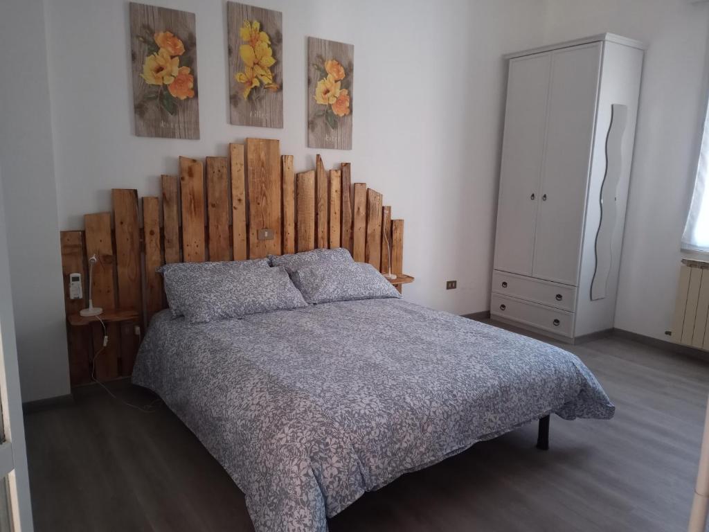 a bedroom with a large bed with a wooden headboard at Ca' d'Luca in Ravenna