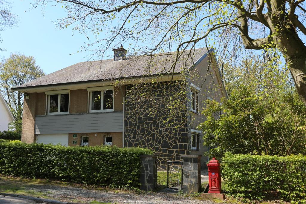 una casa con una boca de incendios roja delante de ella en Gîte du Baroudeur, en Spa