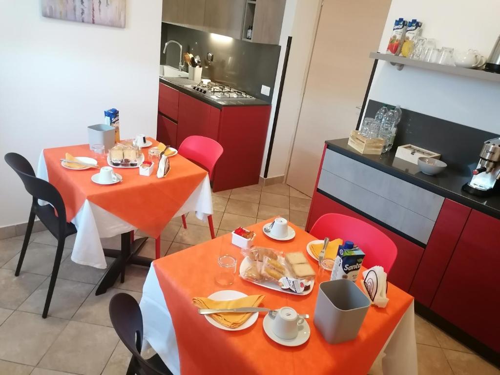 une salle à manger avec deux tables et une cuisine dans l'établissement Hotel Centrale, à Cascia