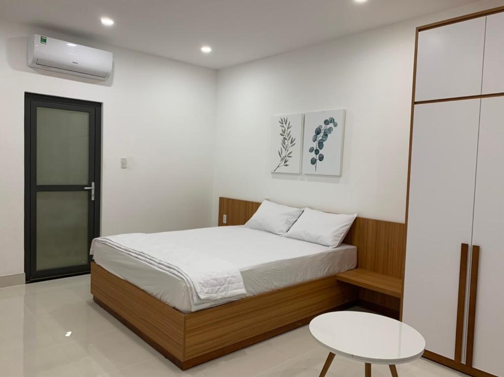 a bedroom with a bed and a table at New Studio 202 District 9 in Xóm Dầu Bình Thới