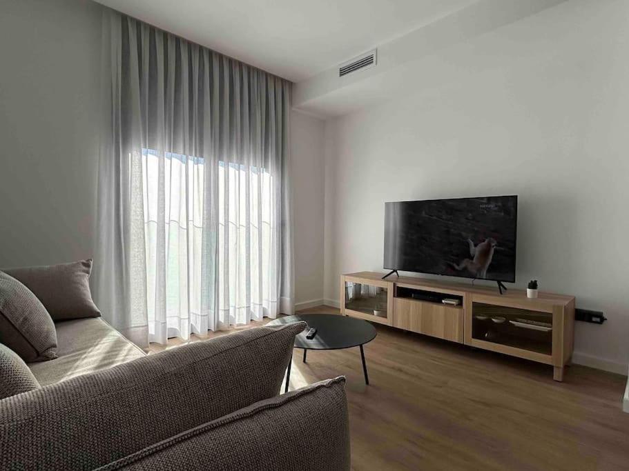 a living room with a couch and a flat screen tv at Estrénalo a minutos de BCN in Sant Feliu de Llobregat