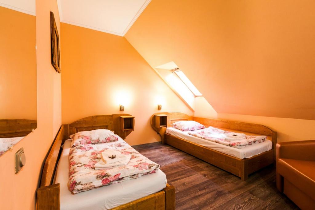 a small room with two beds in a attic at Pensiune si Restaurant Anda in Gheorgheni