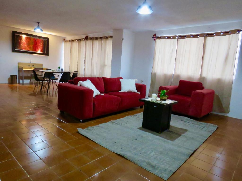 een woonkamer met twee rode banken en een tafel bij Departamento en el centro de Tuxtla Gutiérrez in Tuxtla Gutiérrez