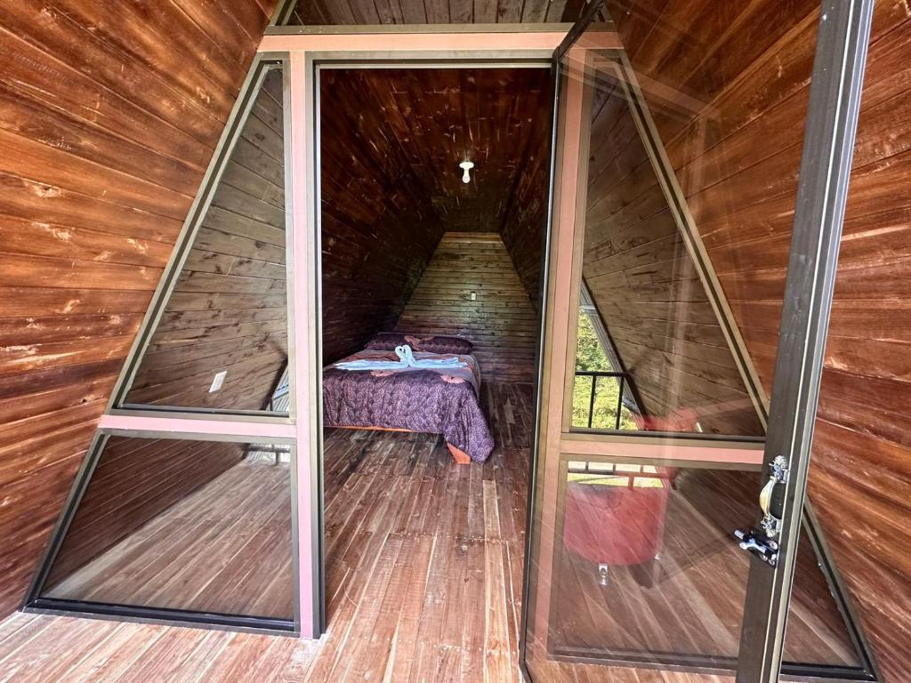 Habitación con cama en una casa de madera en Bungalows Tenorio Montand Lodge, en Upala