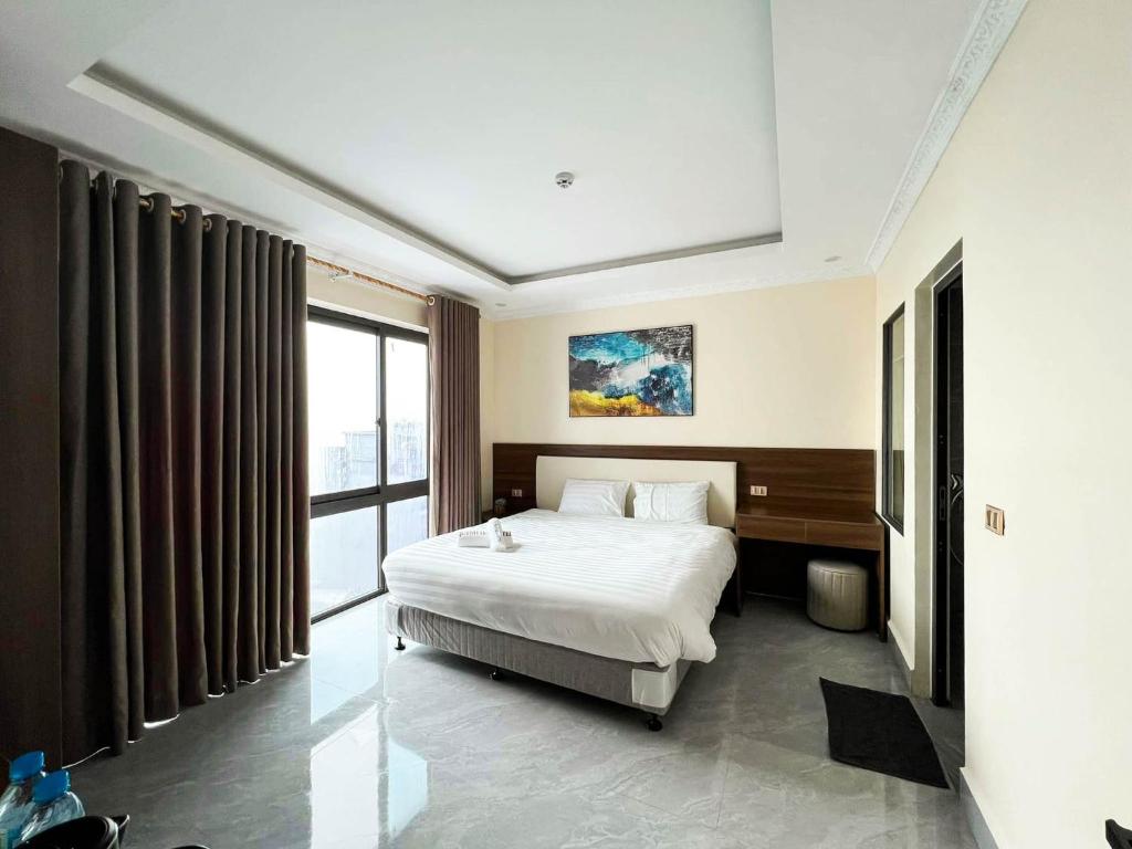 Habitación de hotel con cama y ventana grande en Quỳnh Hoa Hotel Tam Đảo en Tam Ðảo