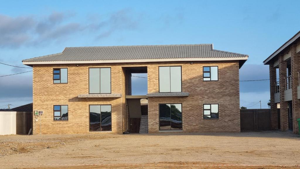 ein Backsteinhaus mit Fenstern auf einer Straße in der Unterkunft Airport Airbnb family units in Richards Bay