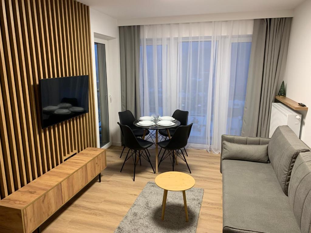 クリニツァ・ズドルイにあるApartament z widokiem Cicha 16B1のリビングルーム(ソファ、テーブル、椅子付)