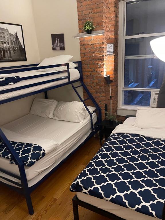 Midtown Nest 1 bedroom Self Serviced Apartment في نيويورك: غرفة بسريرين بطابقين ونافذة