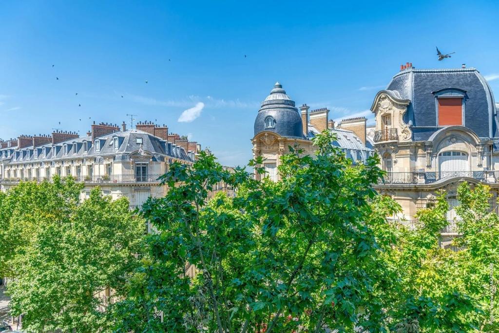 un bâtiment avec un arbre devant lui dans l'établissement Muette - Spontini 1bdr by B'Your Home, à Paris
