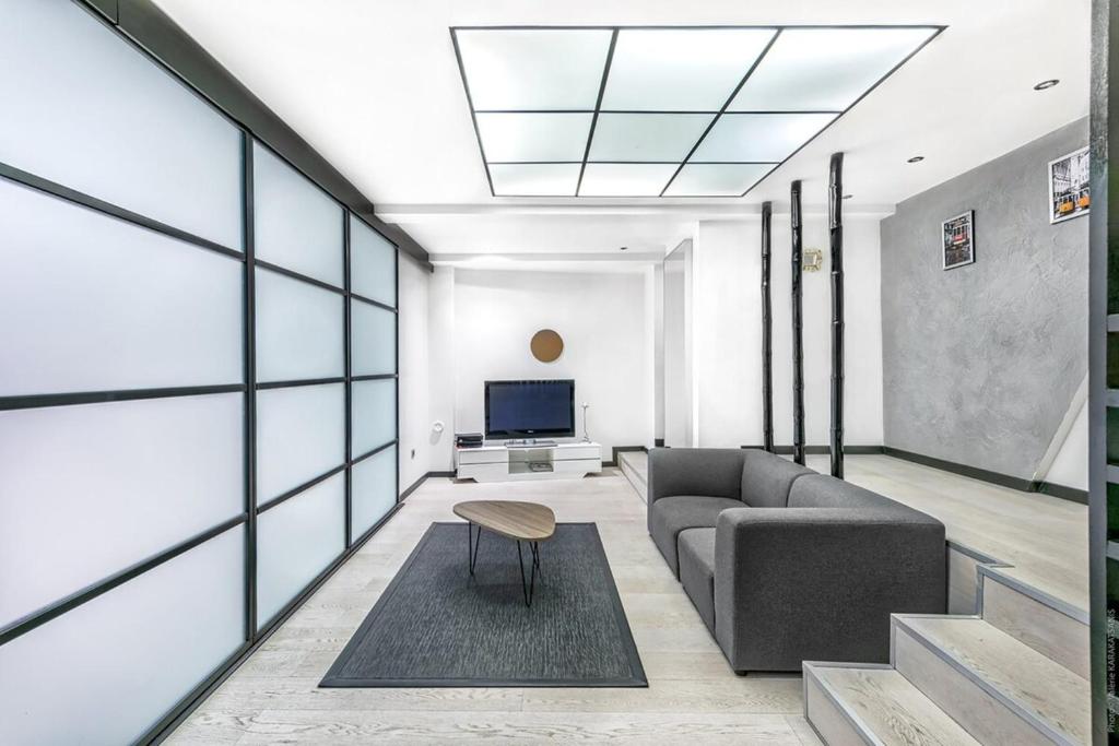 un salon avec un canapé et une télévision dans l'établissement Notre Dame des Champs - Vavin 1bdr - B'Your Home, à Paris