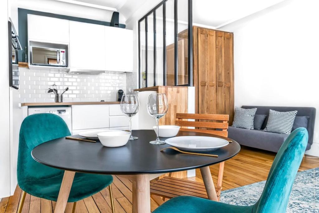 une salle à manger avec une table et des chaises et une cuisine dans l'établissement Gros Caillou - Bourdonnais 1bdr, à Paris