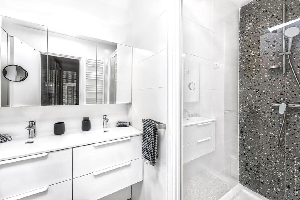 biała łazienka z prysznicem i umywalką w obiekcie Muette - Faisanderie 1bdr by B'Your Home w Paryżu