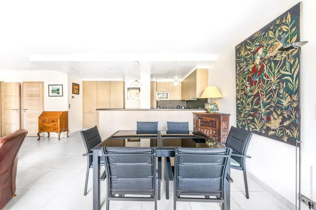 une cuisine et une salle à manger avec une table et des chaises dans l'établissement Maillot Ternes - Saint Ferdinand 3bdr, à Paris