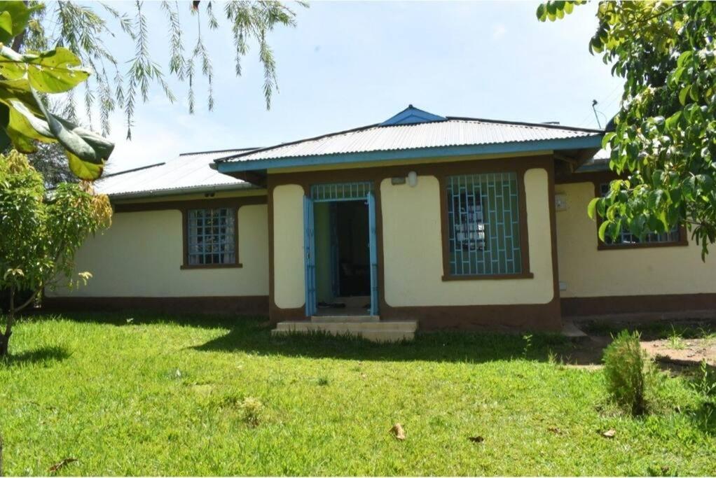 een klein huis met een groen gazon ervoor bij The D'Lux Home, Homa Bay in Marinde