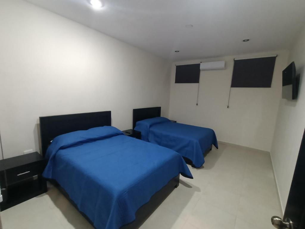 two beds in a small room with blue sheets at OTOCH HE'ELEL in Huay Pix