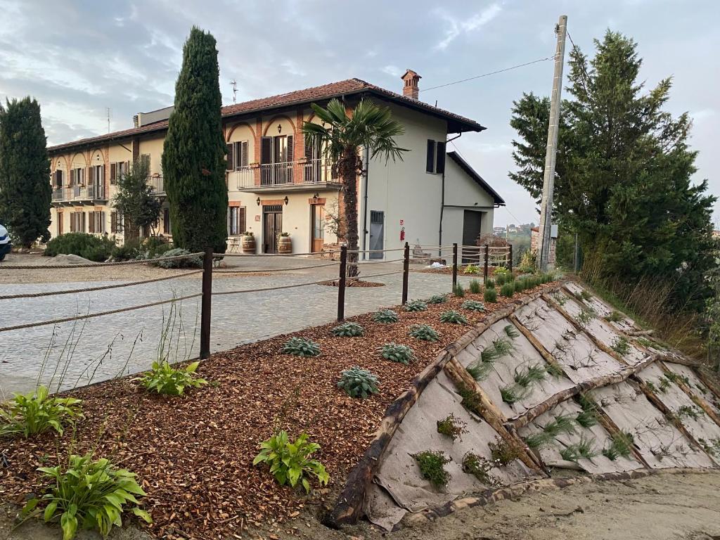 a house with a garden in front of a street at Tenuta Agricola La Cava- Cantina e Agriturismo in San Damiano dʼAsti