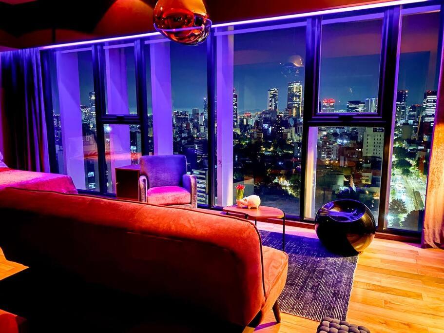 a living room with a red couch and a large window at Suite Chic HCondesa in Mexico City