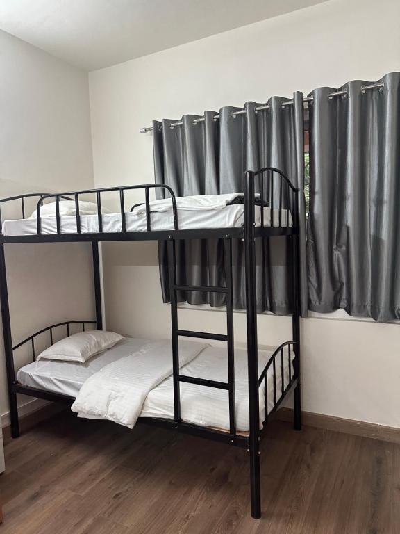 プネにあるElite Stays Viman nagarのカーテン付きのドミトリールームの二段ベッド2台分です。