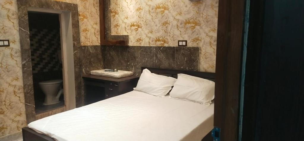 een slaapkamer met een bed met een spiegel en een wastafel bij HOTEL BLUE MOON in kolkata