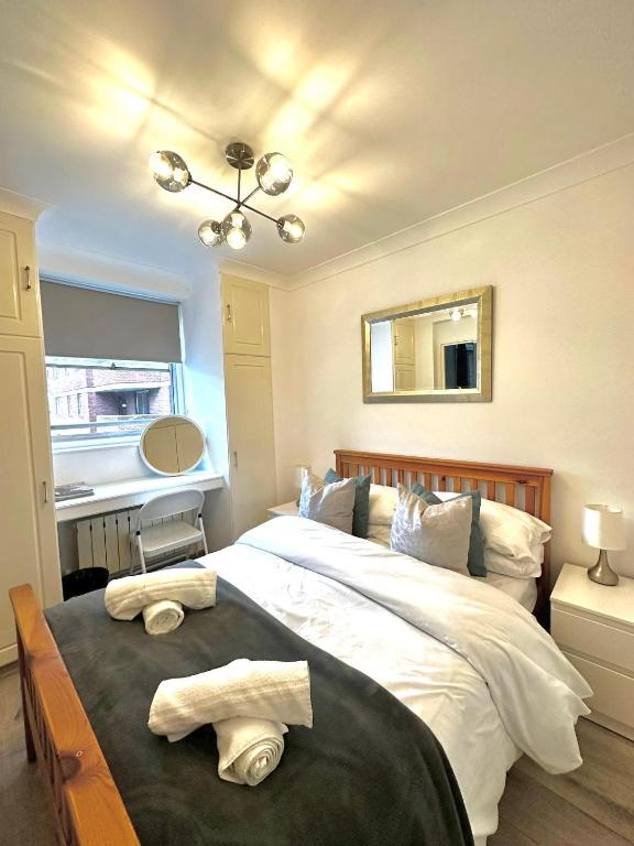 a bedroom with a large bed with towels on it at Luxury Apartment in Central London - 24 7 Security in London